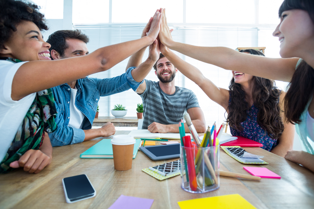 Group of casual artists working at desk in the creative office